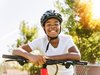 Un élève souriant, appuyé sur le guidon de son vélo.