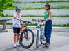 Une jeune fille et un jeune garçon montrent fièrement leur vélo