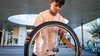 Un élève tient la roue d'un vélo dans sa main - il va probablement le réparer.